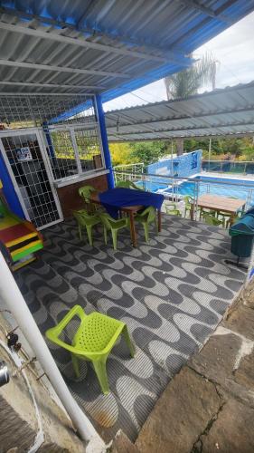 a patio with a table and chairs and a picnic table at Hotel spa la buena vida in Fusagasuga