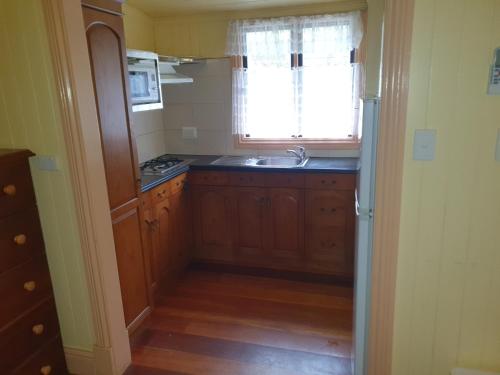 a small kitchen with a sink and a window at Drovers Retreat in Thulimbah
