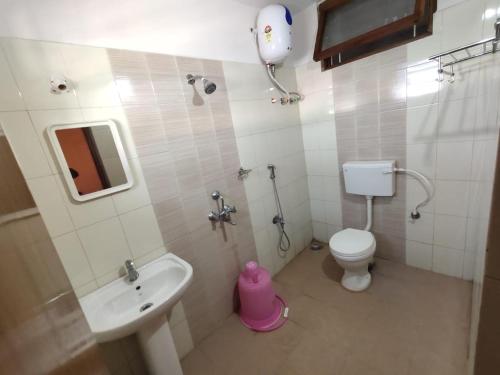 ein kleines Bad mit einem Waschbecken und einem WC in der Unterkunft PARADISE HOME STAY in Visakhapatnam