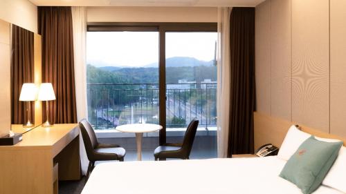 a hotel room with a bed and a large window at Chuncheon Eston Hotel in Chuncheon