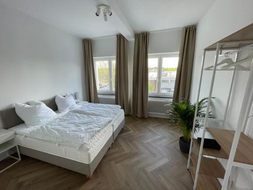 een slaapkamer met een bed en een plant erin bij Airport Apartments for 4 - Kitchen - Parking with eCharging in Hamburg