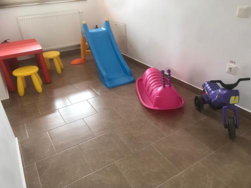 Habitación con juguetes infantiles y suelo de baldosa. en Casa Bogát Ház en Harghita-Băi