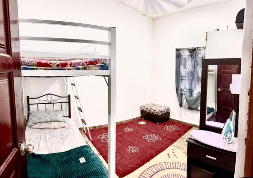 1 dormitorio con litera y alfombra roja en Isyfaq Homestay 2 bedroom & 2 bathroom, en Kota Tinggi