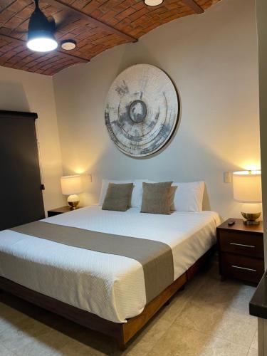 a bedroom with a large bed and a clock on the wall at Hotel NG in Ameca