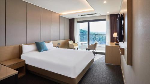 Chuncheon Eston Hotel في تشنتشون: غرفة فندقية بسرير كبير ونافذة