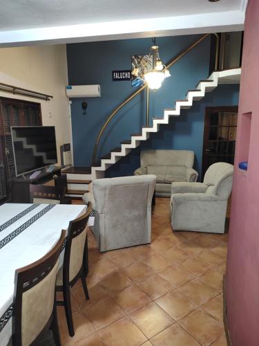 sala de estar con escalera, mesa y sillas en Máximo cdlu en Concepción del Uruguay