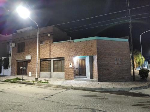 un edificio de ladrillo por la noche con luz de la calle en Máximo cdlu en Concepción del Uruguay