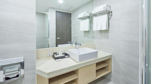 y baño con lavabo y espejo. en Chuncheon Eston Hotel, en Chuncheon