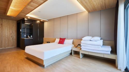 a bedroom with a white bed and a chair at Chuncheon Eston Hotel in Chuncheon