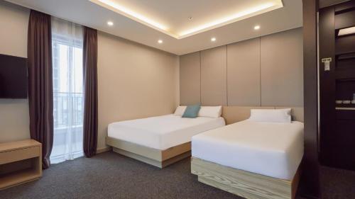 a bedroom with two beds and a window at Chuncheon Eston Hotel in Chuncheon