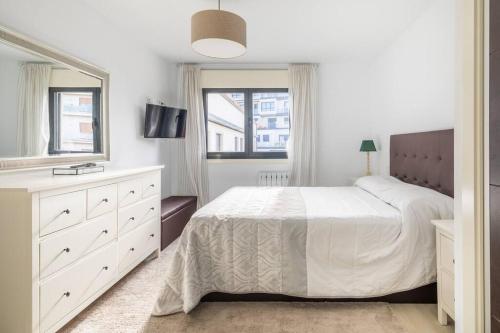 1 dormitorio blanco con 1 cama grande y vestidor en Piso en Ribeira, primera línea., en Ribeira