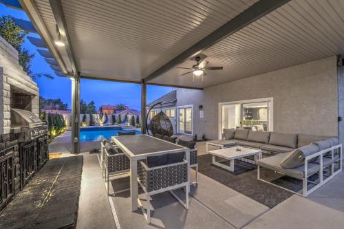 a patio with a couch and a table at Sunset Swim, Luxury Vegas Villa with Pool, Hot Tub in Las Vegas