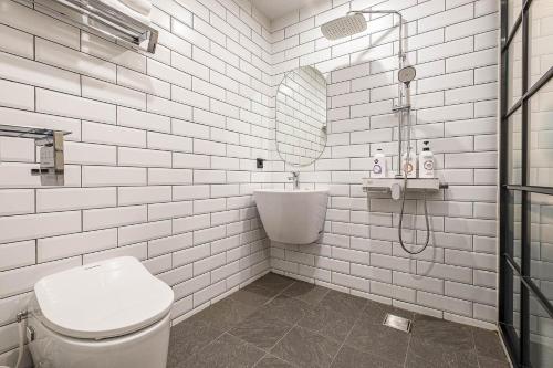 un bagno bianco con doccia e WC di Heritage31 Hotel a Seul