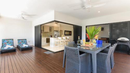 ein Wohnzimmer mit Tisch und ein Esszimmer in der Unterkunft Cascade Drive Port Douglas in Craiglie