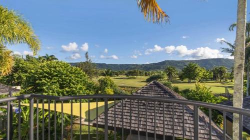 a balcony with a view of a golf course at Catalina Port Douglas in Port Douglas