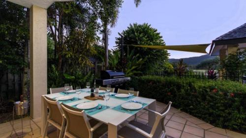a white table and chairs on a patio at Catalina Port Douglas in Port Douglas
