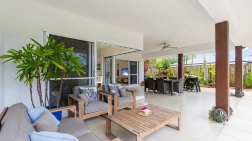 a living room with a couch and a table at Cascade Links Port Douglas in Craiglie