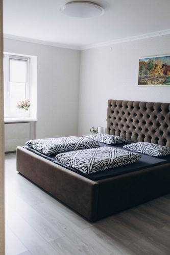 ein Schlafzimmer mit einem Bett mit einem großen Bettrahmen in der Unterkunft Однокімнатна дизайнерська квартира поруч з термальними водами in Berehowe