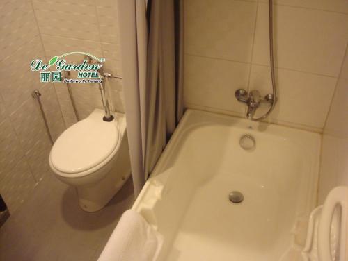 a bathroom with a toilet and a bath tub next to at De' Garden Hotel, Butterworth in Butterworth