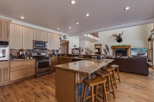 a large kitchen with a large island with bar stools at Alpine Airspace by KABINO Airpark Foosball Garage Satellite in Alpine