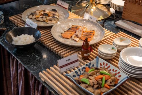 a buffet with plates of food and a bottle of beer at Toshi Center Hotel in Tokyo