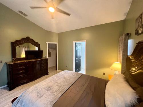 a bedroom with a large bed and a mirror at Grand Superior 4BR Pool House near Disney Parks in Davenport
