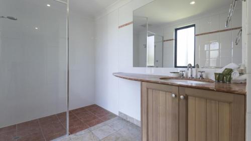 Un baño blanco con lavabo y ducha. en 1 The Point Apartments Port Douglas, en Port Douglas