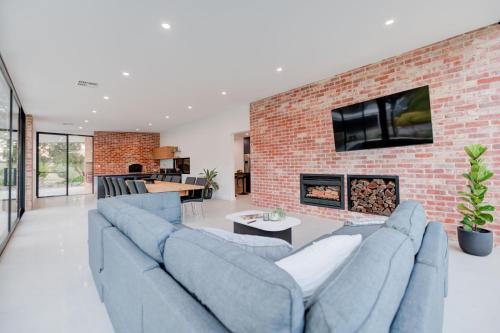 a living room with blue couches and a brick wall at CASALE ESTATE in Nuriootpa