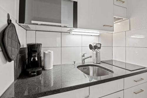 cocina con fregadero y encimera en City Center-Twin Bed-Coffee-Workplace-Washer, en Winterthur