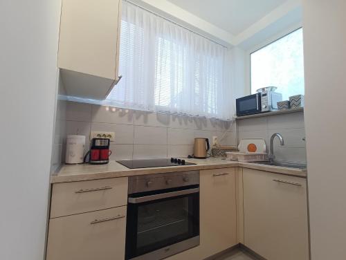 a kitchen with white cabinets and a sink and a window at Apartment Fontana Felicita in Zadar