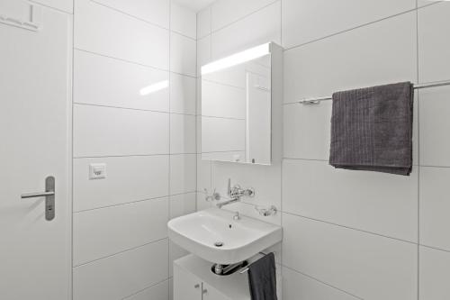 a white bathroom with a sink and a mirror at Pearlstay - City Center Twin Bed Workplace Washer in Winterthur