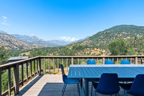 una mesa y sillas en una terraza con montañas al fondo en Mountain View, Hot Tub, Open Kitchen, 10m to Sequoia, en Three Rivers