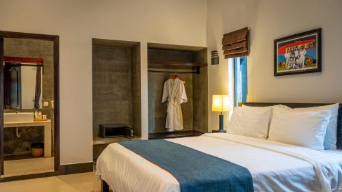 a bedroom with a bed and a robe hanging in a window at Grange in Siem Reap