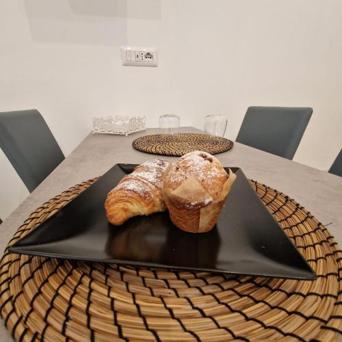 a table with a black plate with two pastries on it at B&B UNICI GRAMMICHELE in Grammichele