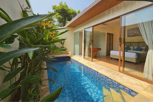 a villa with a swimming pool next to a bedroom at Jepara Garden Resort in Jepara