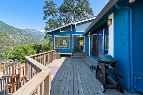 a blue house with a wooden deck with a stools at Mountain View, Hot Tub, Open Kitchen, 10m to Sequoia in Three Rivers