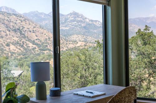 a table with a lamp in front of a window at Mountain View, Hot Tub, Open Kitchen, 10m to Sequoia in Three Rivers