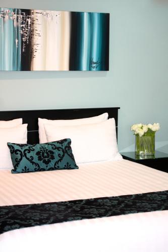 a bed with a black and white comforter and a pillow at Camelot On Ulster in Hamilton