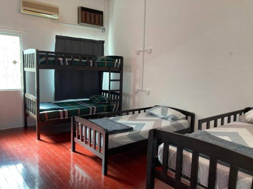 a room with two bunk beds and a window at Travellers Diary Guesthouse in Melaka