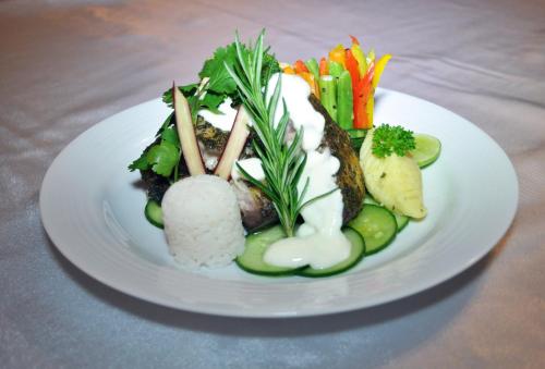 talerz z jedzeniem, sushi i warzywami na stole w obiekcie Hill Cottage w mieście Nuwara Eliya