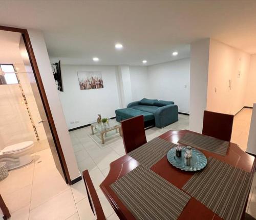 ein Wohnzimmer mit einem Tisch und einem Sofa in der Unterkunft Encantador apartamento cerca al aeropuerto in Bogotá