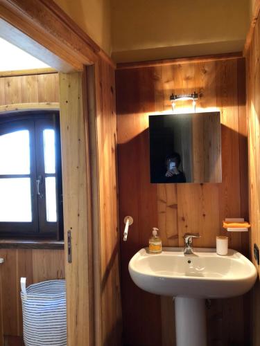 a bathroom with a sink and a tv on the wall at LA CASA DEL CASTELLANO in Cinzano