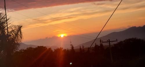 a sunset with the sun setting in the mountains at Hotel spa la buena vida in Fusagasuga
