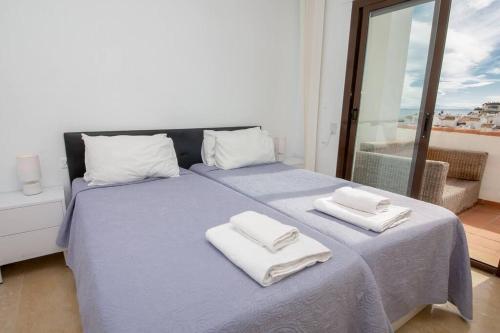 マニルバにあるMarina Real 433のベッドルーム1室(ブルーベッド1台、タオル付)