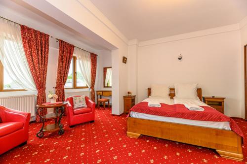 Schlafzimmer mit einem Bett und einem roten Teppich in der Unterkunft Panoramic Center Rooms in Braşov