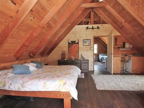 1 dormitorio con 1 cama grande en una cabaña de madera en ALOHA AMITY, en Amity Point