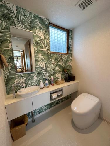 La salle de bains est pourvue de toilettes, d'un lavabo et d'un miroir. dans l'établissement ResortHouse-KAPUKA, à Chatan
