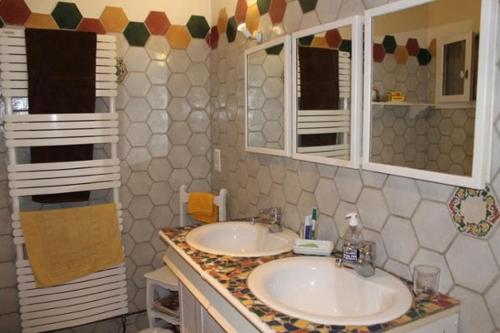 een badkamer met 2 wastafels en 2 spiegels bij Le Magnolia in La Rochefoucauld