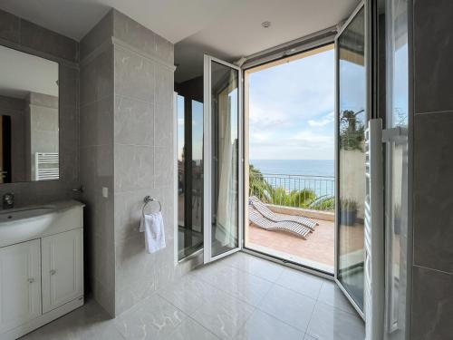 een badkamer met uitzicht op de oceaan vanaf een balkon bij Villa l'ensoleillée vue panoramique mer, 250 m de la plage et du centre ville in Menton