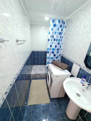 a blue and white bathroom with a sink and a toilet at Yanko in Kokshetau